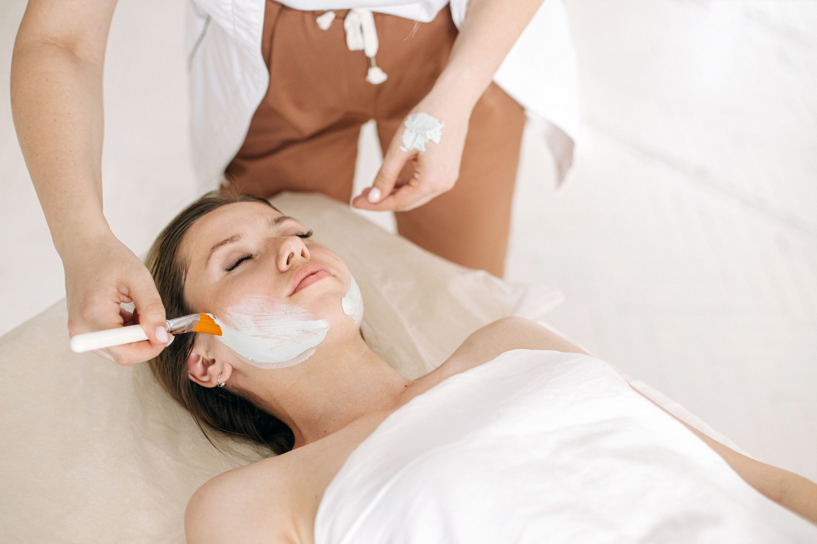 Therapist applying a facial treatment to a client at the salon